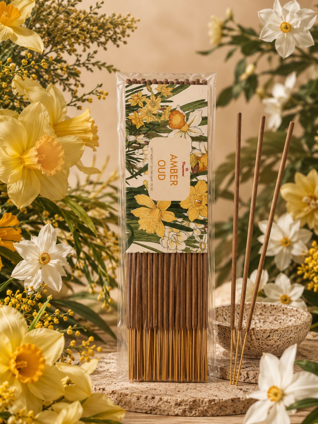 Amber oud agarbatti incense sticks in tall pack with flower display