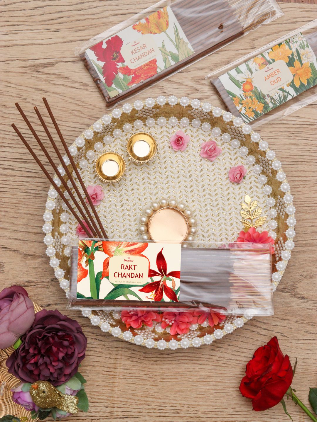 Incense sticks pack with floral label, loose wooden sticks, and decorative white tray