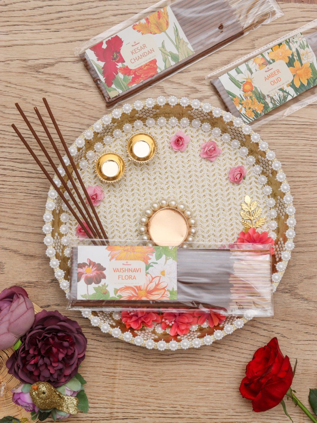 Incense sticks and floral incense packet resting on a beaded circular tray