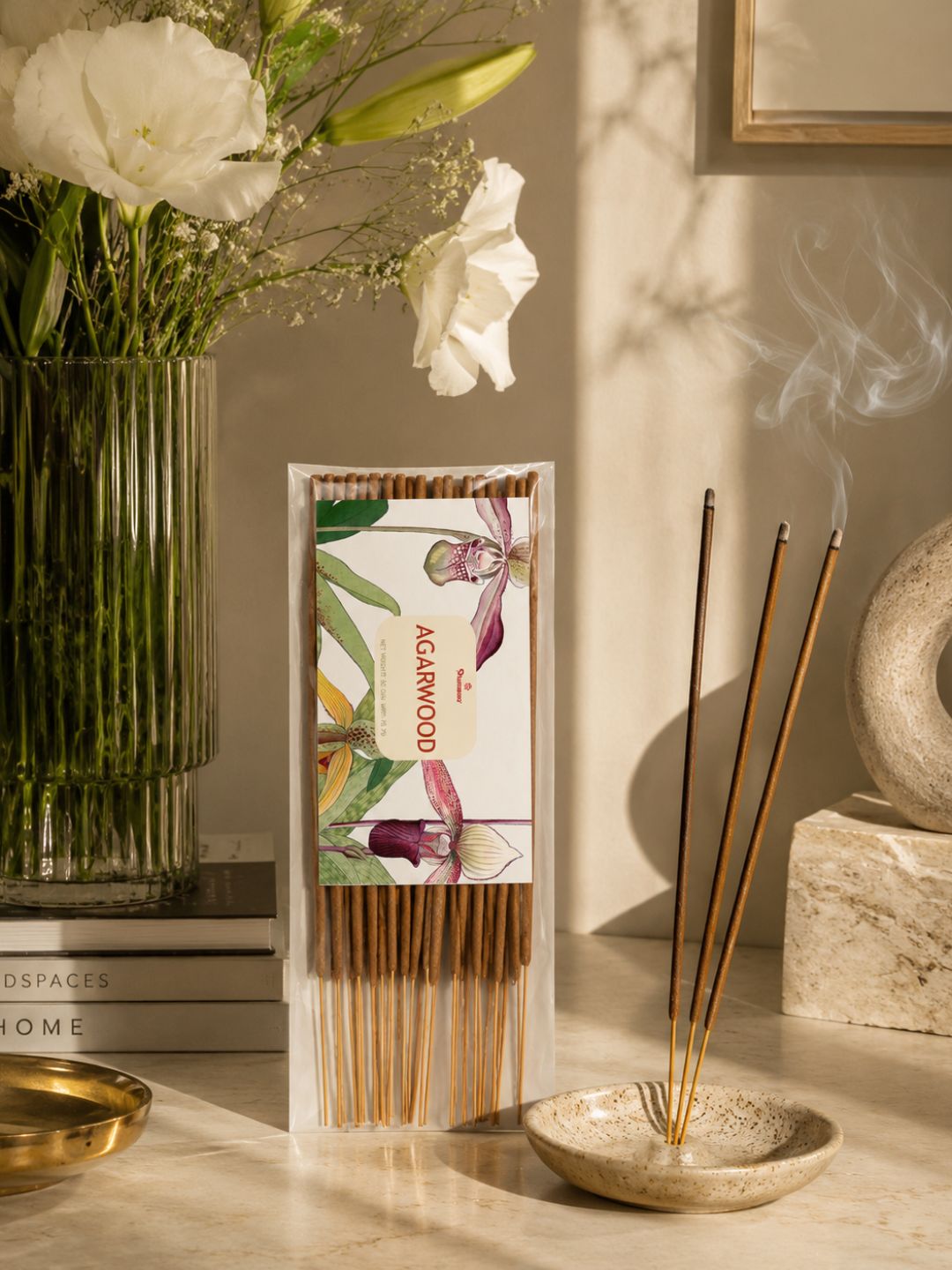 Agarwood incense sticks pack on tabletop with several burning sticks standing