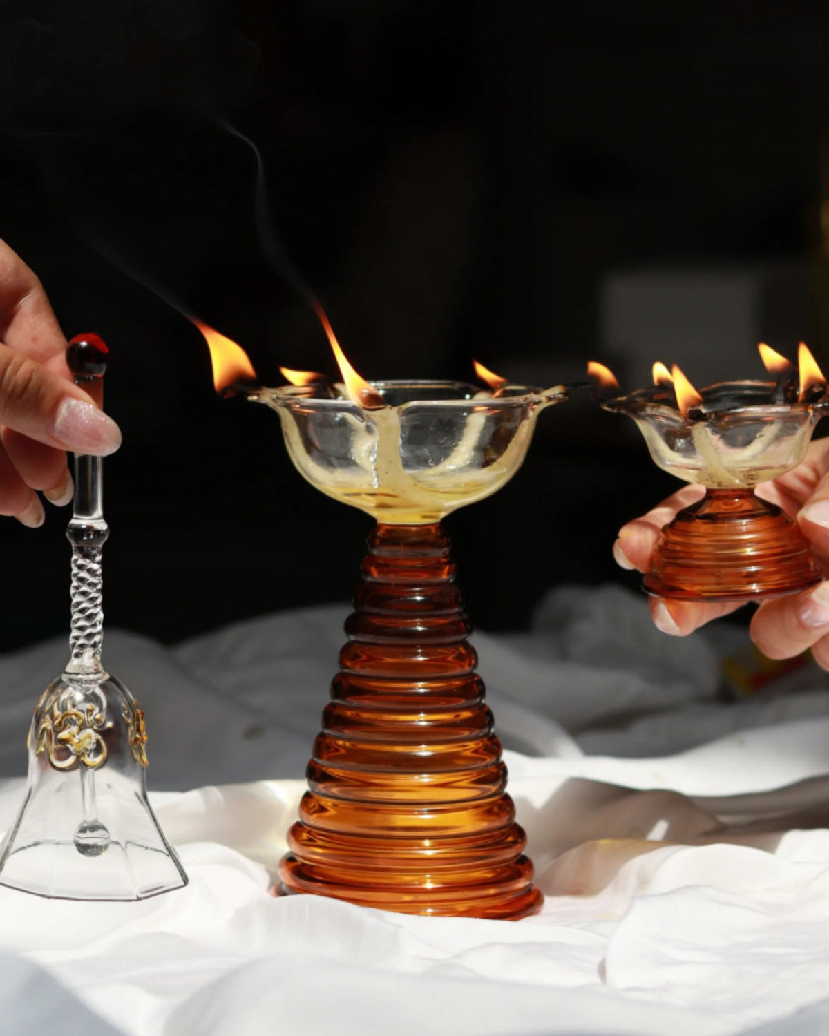 Amber ribbed glass puja diya holder with clear bowl, burning wicks