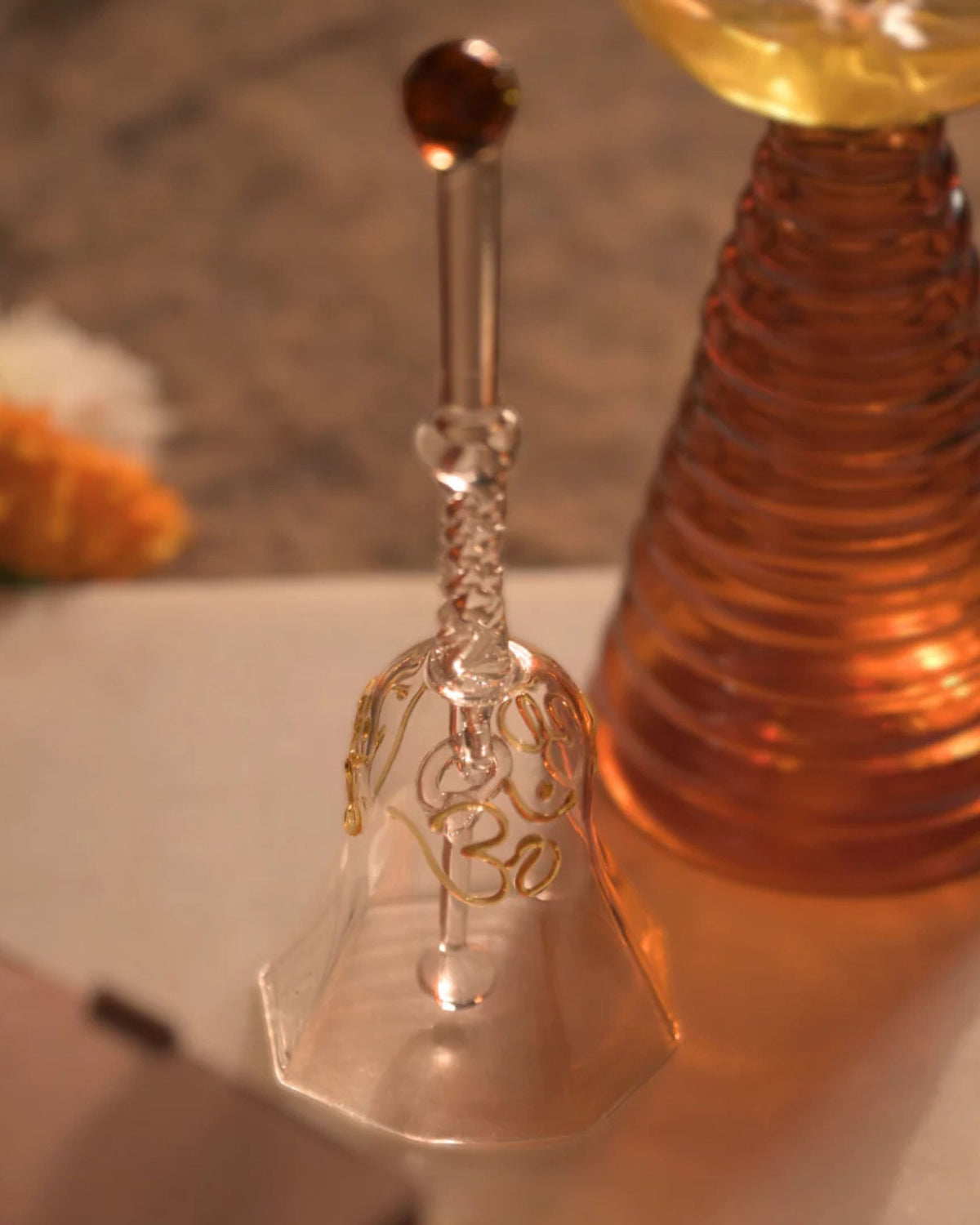 Clear glass puja diya holder with embossed design on slender stem