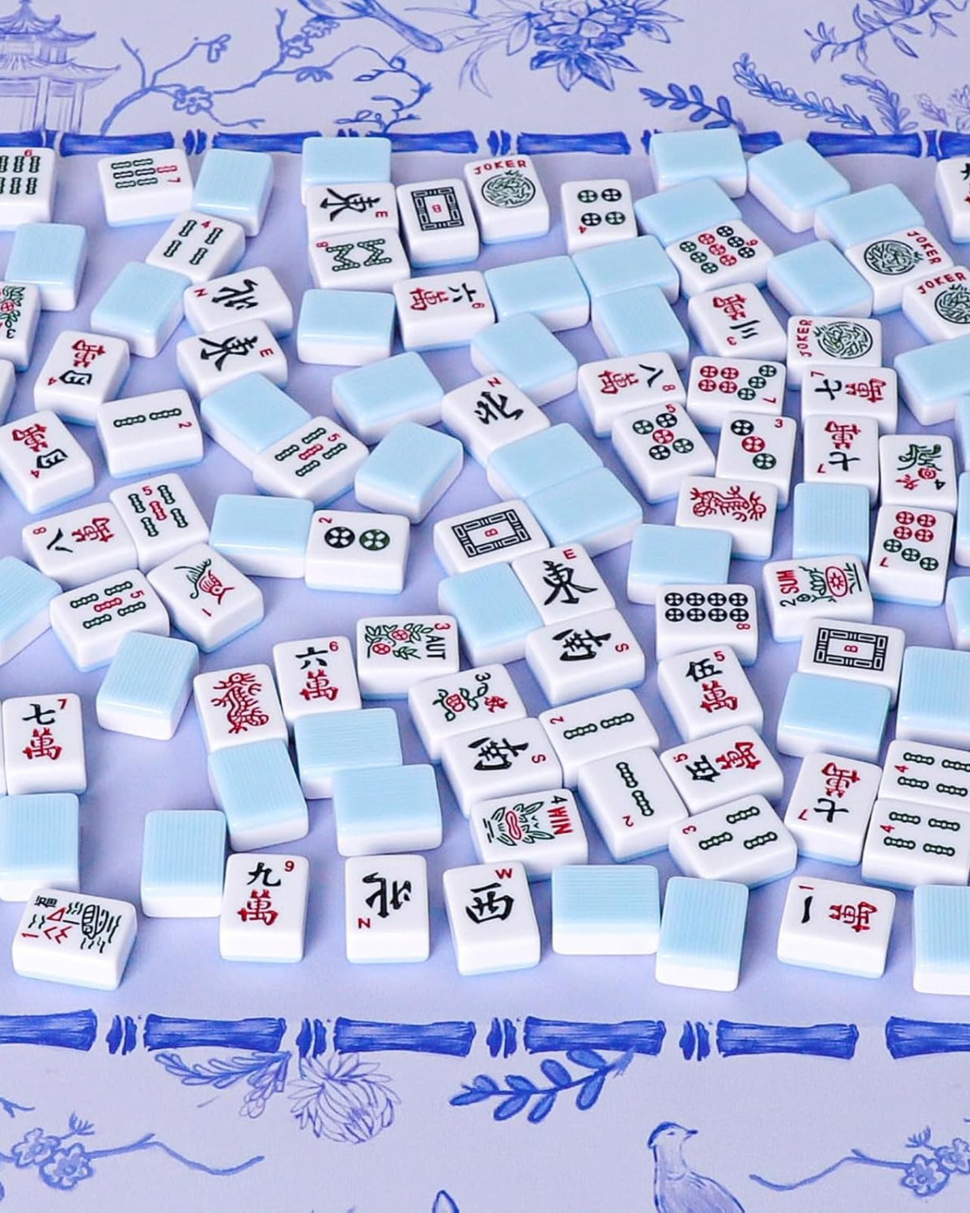 Blue and white mahjong tiles with printed Chinese suit symbols, loose layout