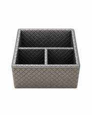 Three-compartment remote holder in metallic silver-gray leatherette with diamond pattern.