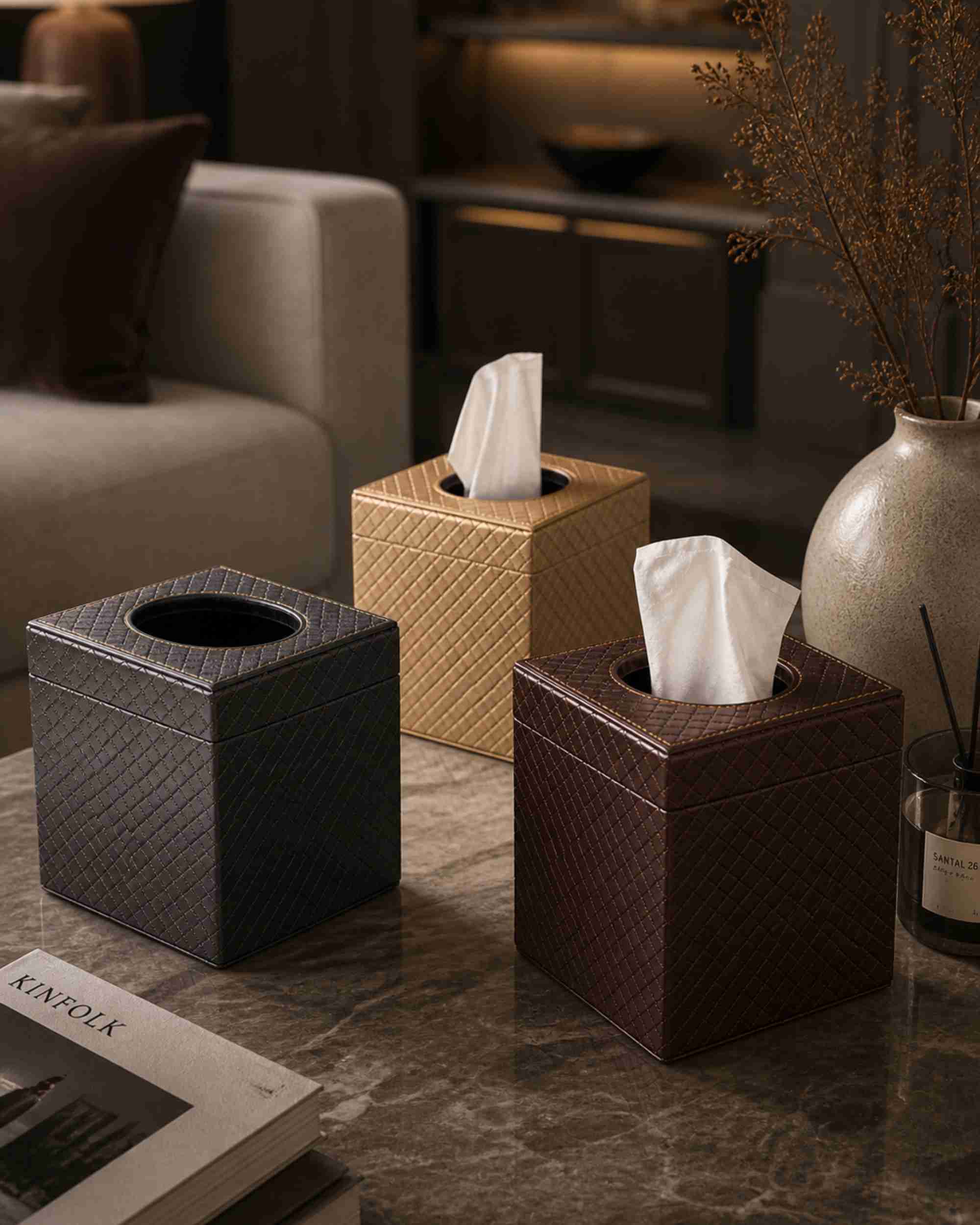 Metallic leatherette tissue box holders, dark and tan textured squares on tabletop with tissues