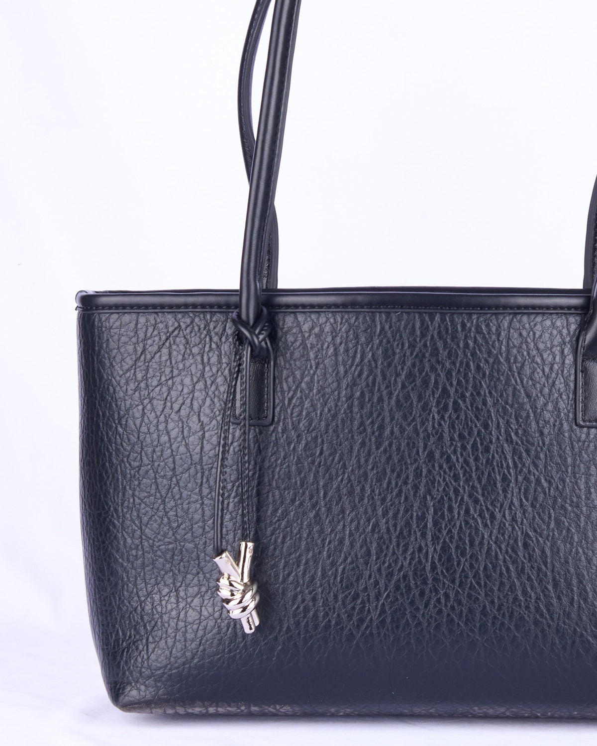 Black leather women's handbag with structured sides and key charm on front panel