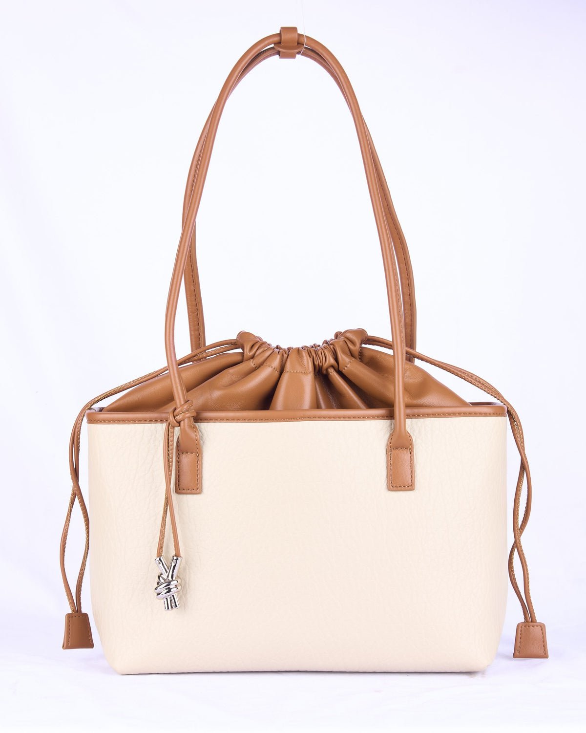 Cream leather-look handbag with drawstring closure, double handles, and tassel charm