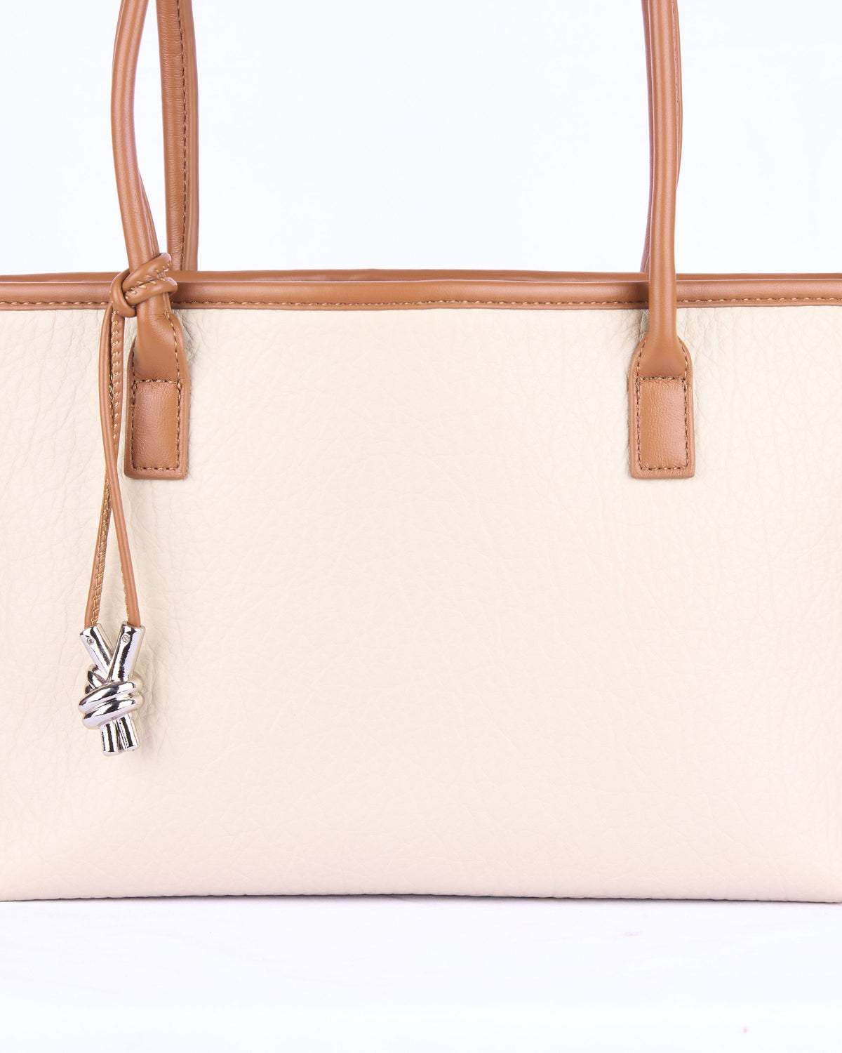 Light cream women's handbag with tan leather handles and drawstring closure key charm
