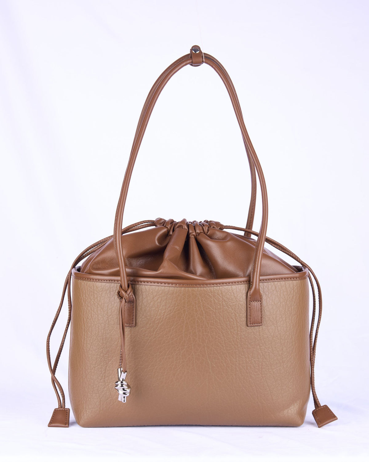Light brown leather-look handbag with drawstring top, two front straps, and tassel cords