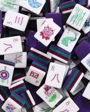 Acrylic mahjong tiles set with white faces, purple and green suit symbols and numbers.