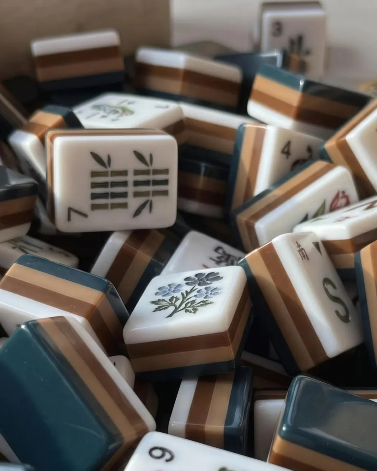 Acrylic mahjong tiles in a pile, with a bamboo-number face and blue-striped backs