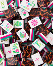 Close-up acrylic mahjong tiles with tortoise-pattern backs and flower, bird, number faces