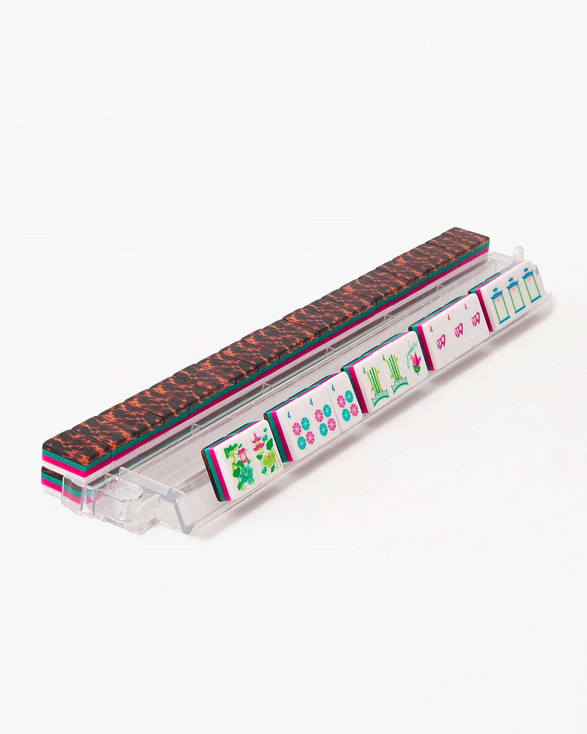 Acrylic mahjong tiles in a clear tray, showing tortoise-pattern backs and green, pink faces
