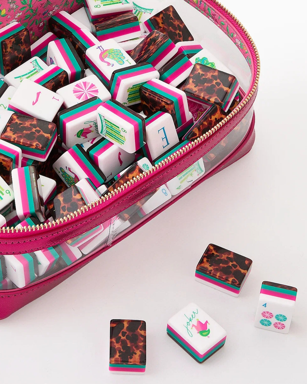 Acrylic mahjong tiles scattered, showing tortoise-pattern backs and bamboo/lantern faces
