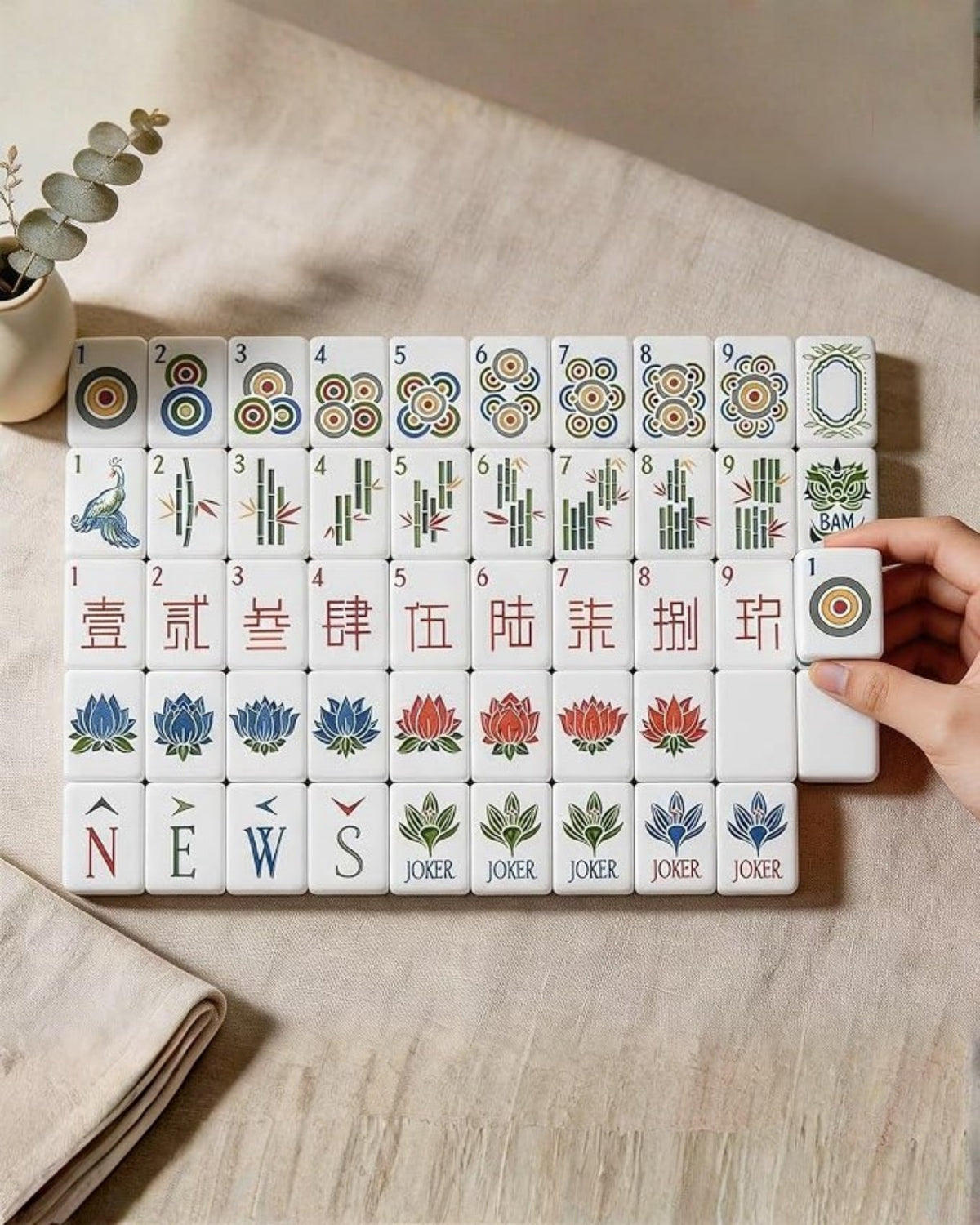 Acrylic mahjong tiles on table, showing numbers, suits, honors, and joker tiles