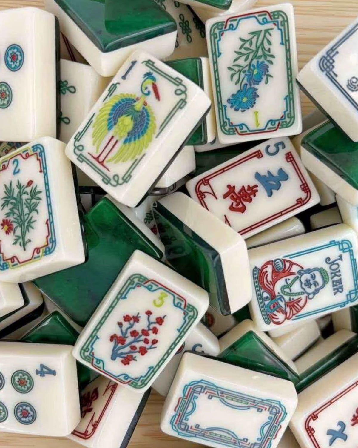 Pile of mahjong tiles with colorful faces and green backs