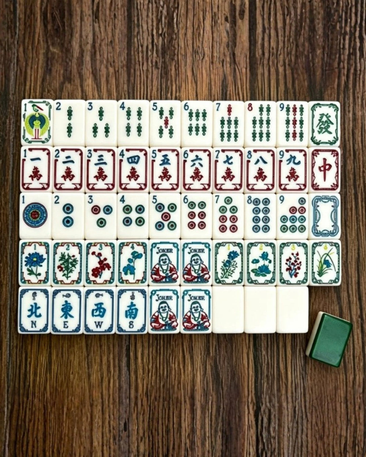 Mahjong tiles arranged in rows, showing Joker, suits, and character tiles