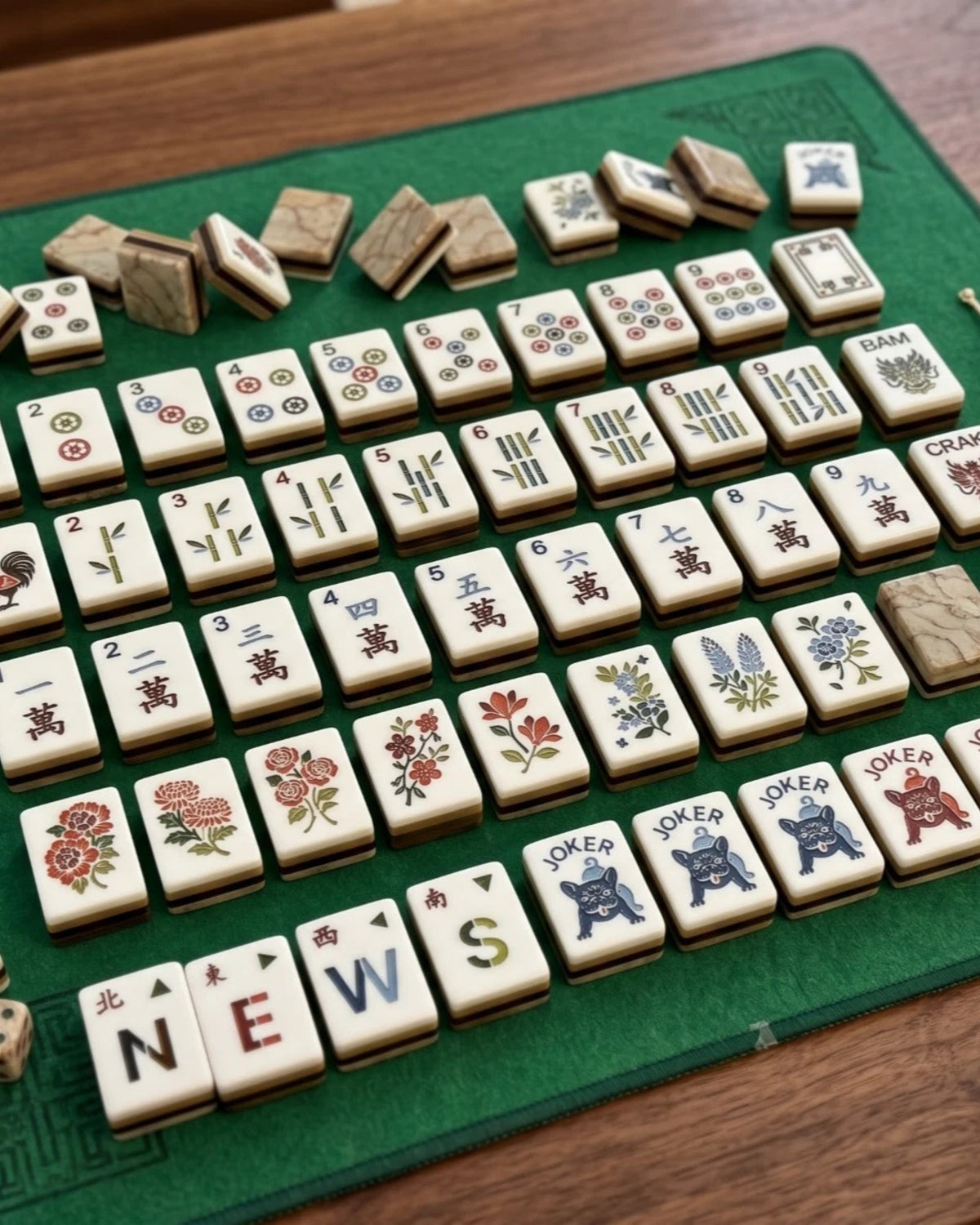 Mahjong tiles set with white face tiles showing suit icons, characters, and 'NEW' letters