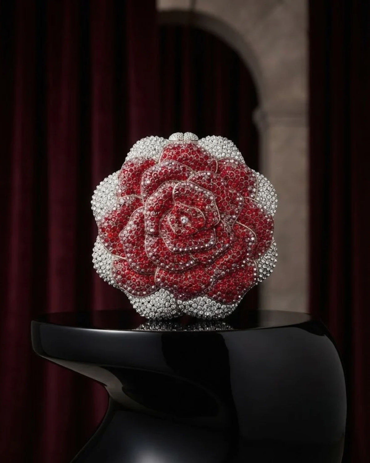 Jeweled red-and-silver rose clutch bag on black stand, rounded top