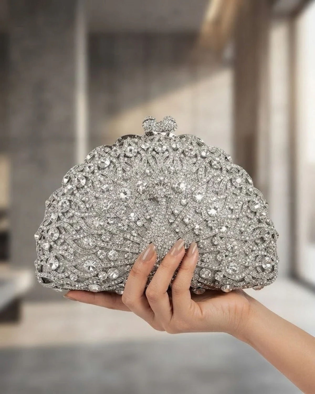 Silver rhinestone crystal clutch bag with fan pattern; hand-holding view