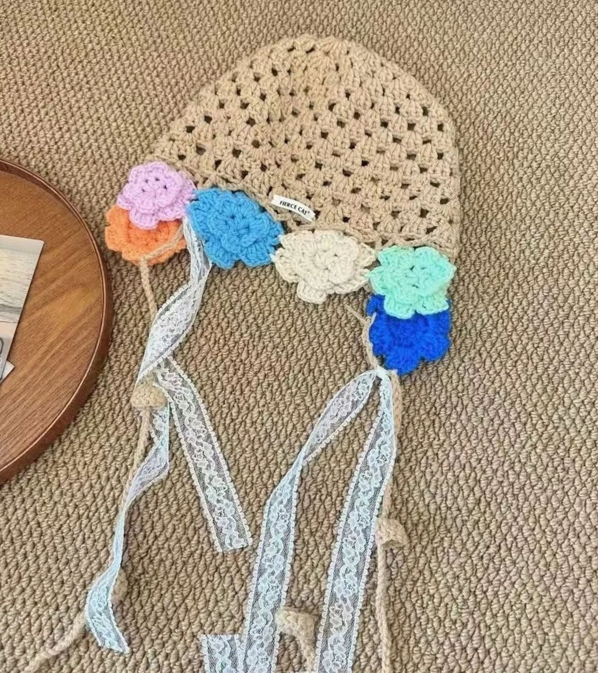 Crochet bonnet top with multicolor 3D flowers and long white lace ribbon streamers