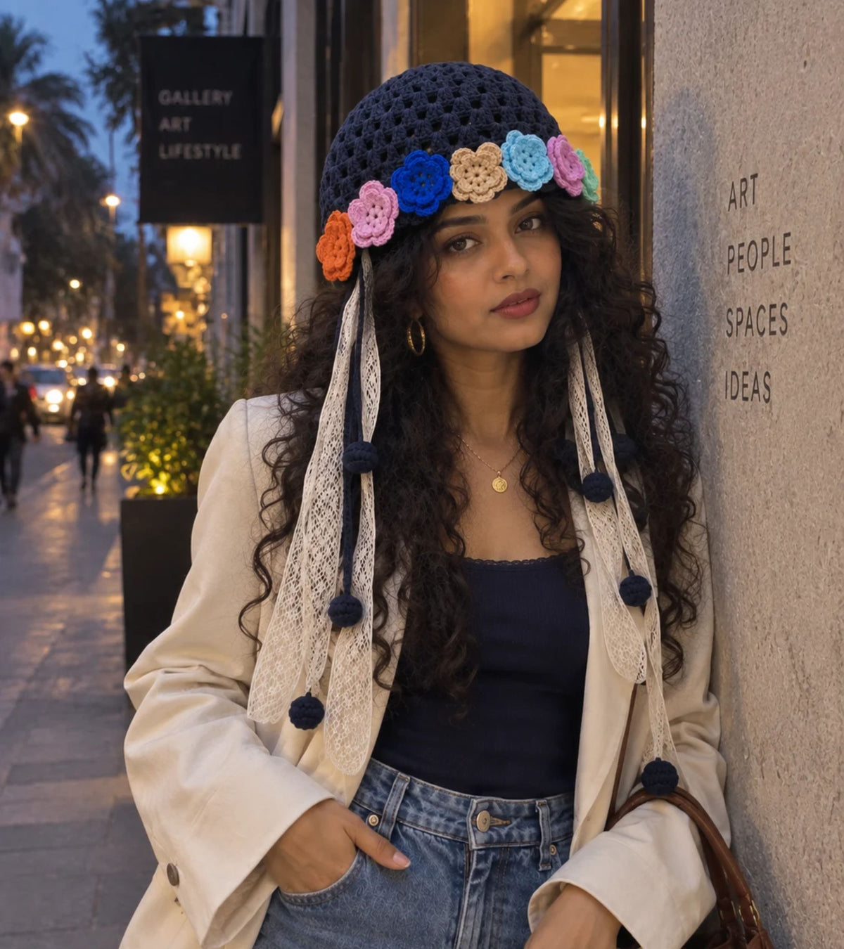 Navy crochet bonnet with multicolor 3D flower bands and long lace tails with pom-poms