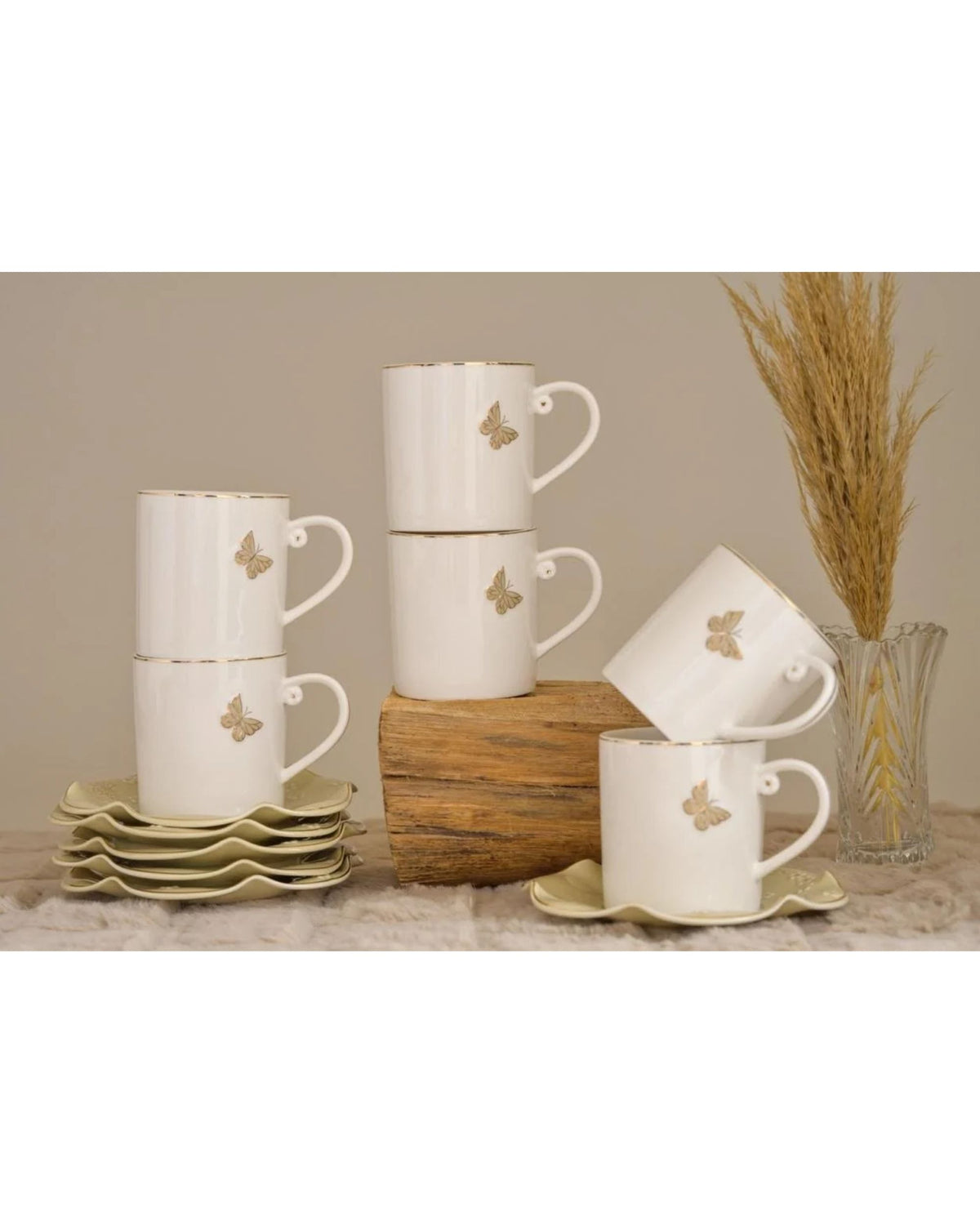 White coffee mugs with gold butterfly designs and matching saucers