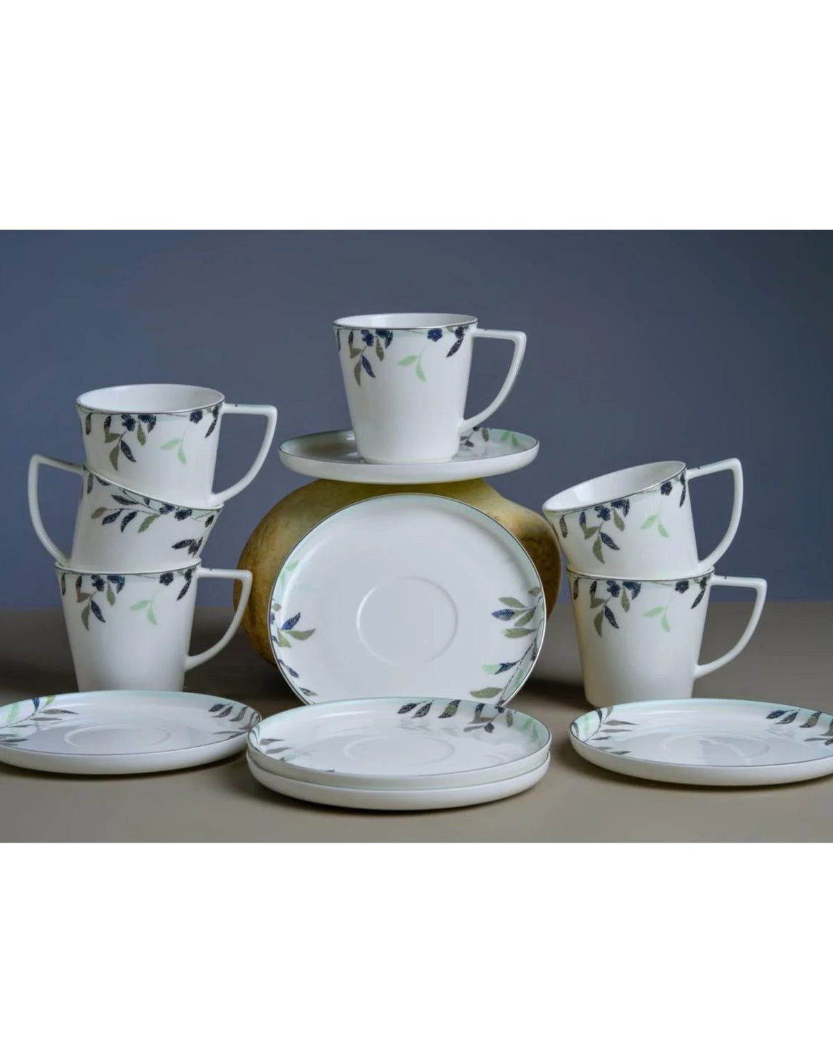 White floral print mugs and matching saucers displayed as a set.