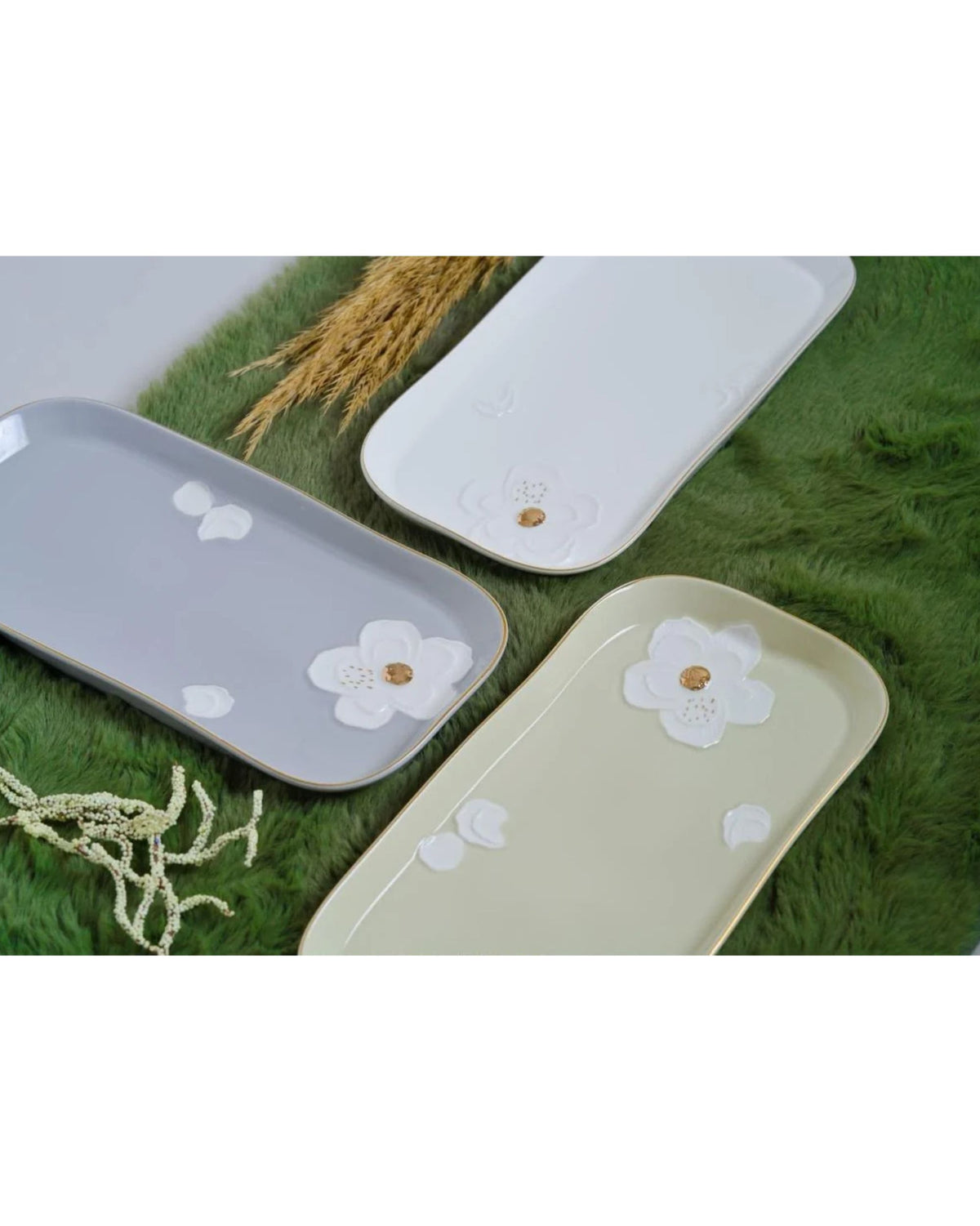 Serving platters with raised white flowers, gold details, and slim gold rims