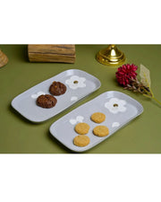 Pair of white serving platters with raised floral designs and gold accents
