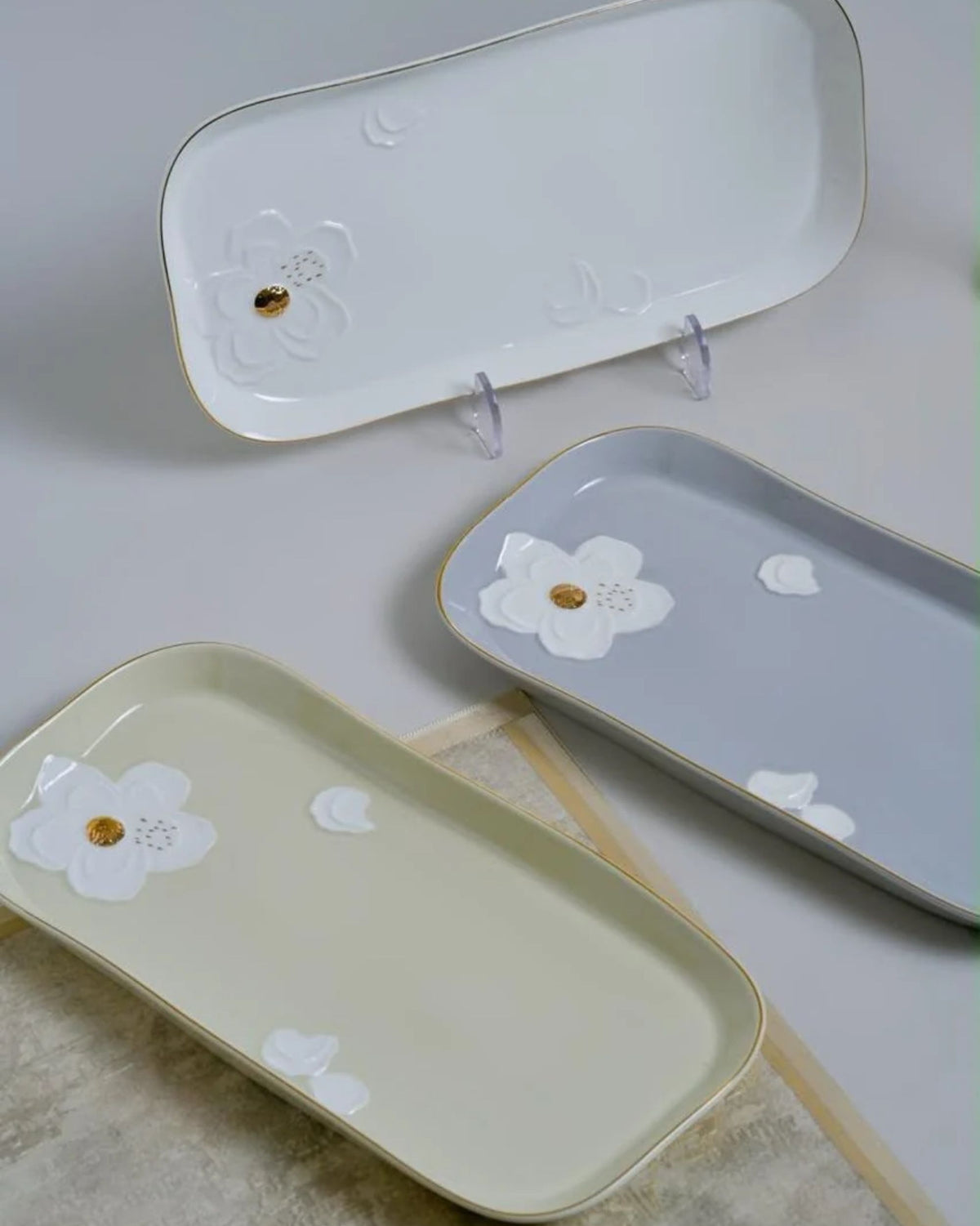 Rectangular platters with raised floral designs and gold accents
