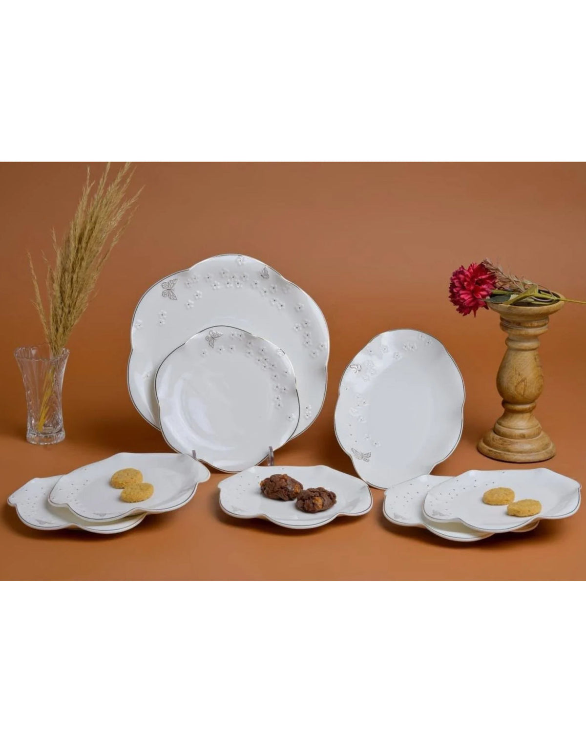 White ceramic plate set with scalloped edges, raised flower details, gold trim, and butterfly motifs