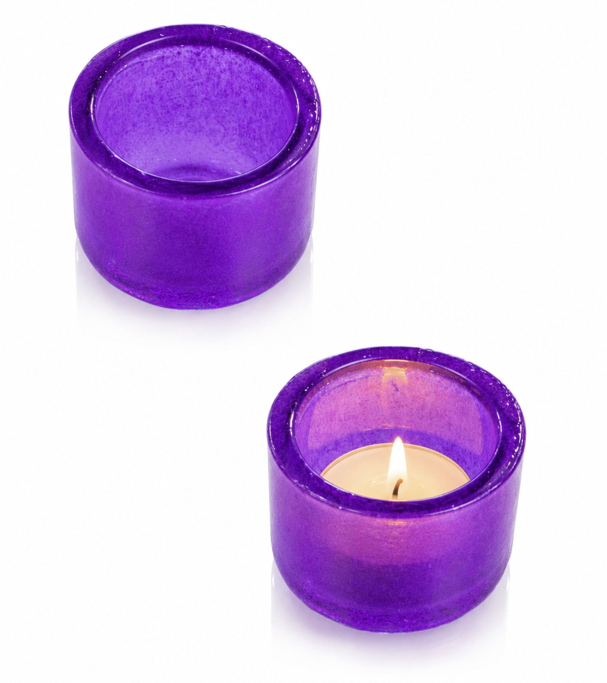 Two purple glass votive candle holders with one lit tealight
