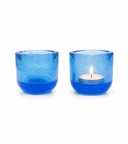 Blue glass votive candle holders with tealight candles, round short cylinders