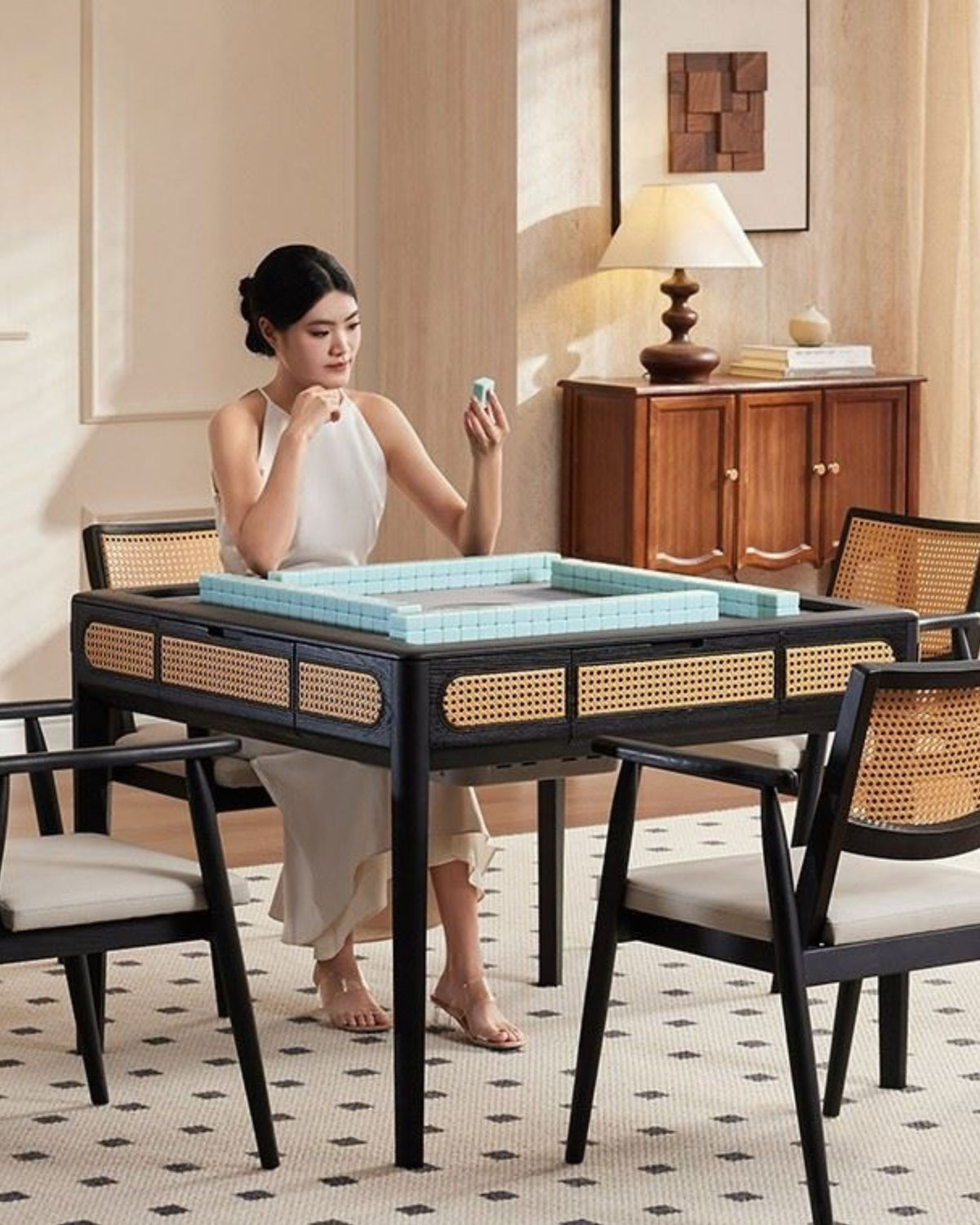 Mahjong game table with black top, wicker chairs, and tiled playing area