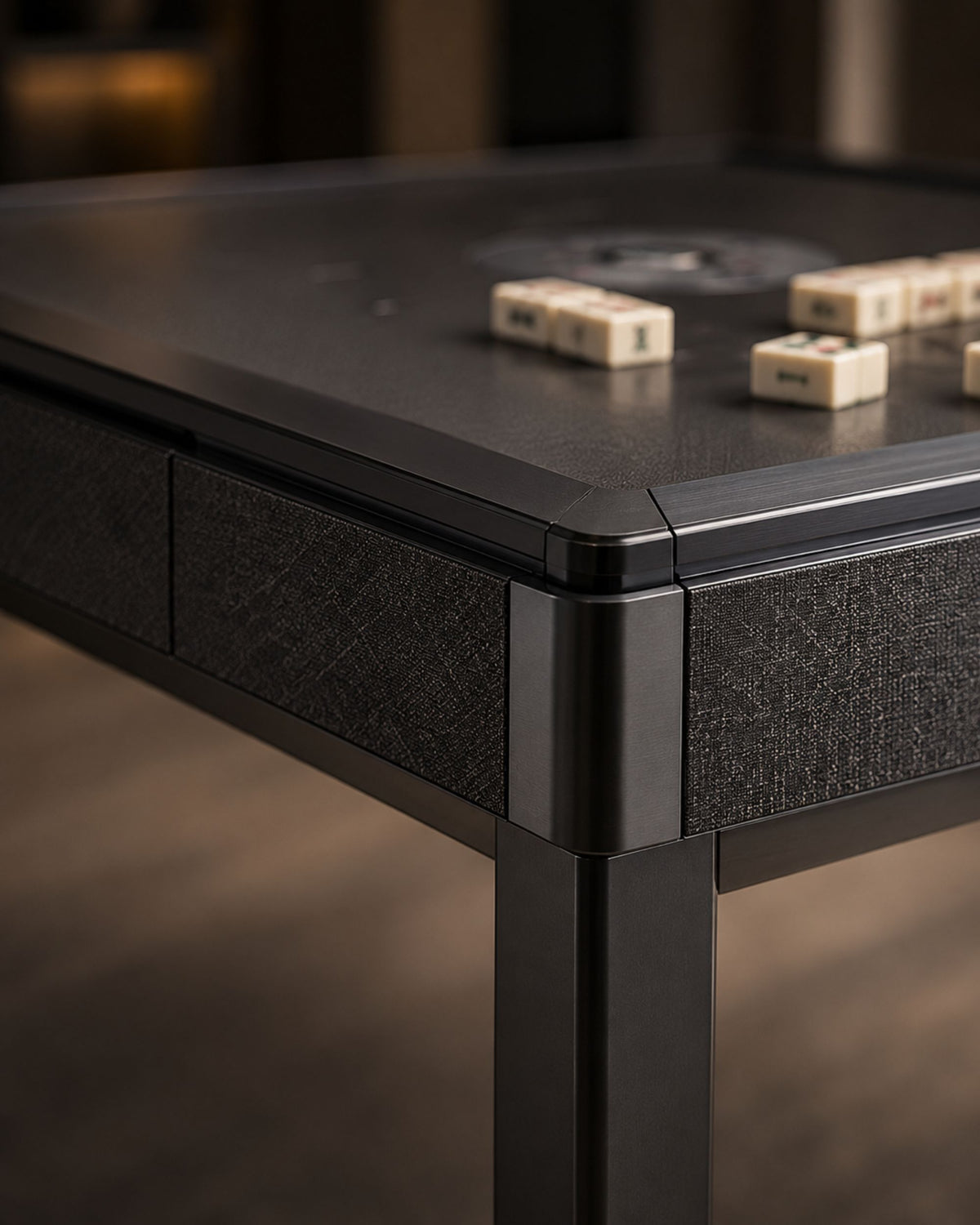 Close-up of black mahjong table corner with clear top and textured sides
