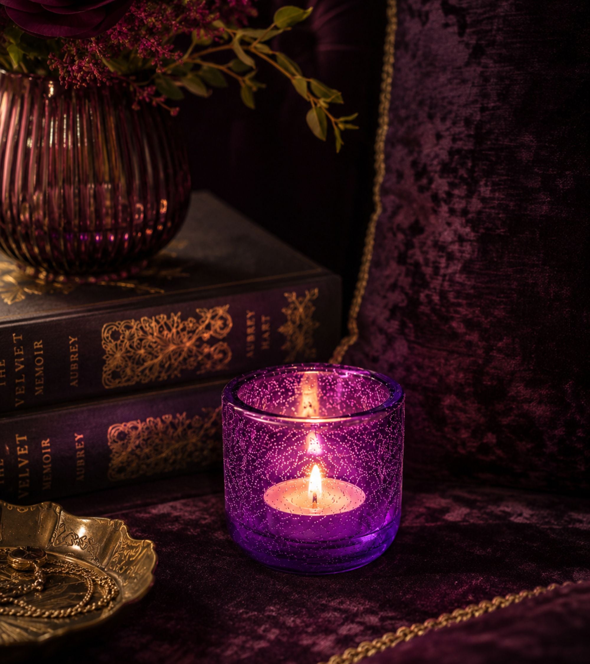 Purple glass votive candle holder with glowing tealight