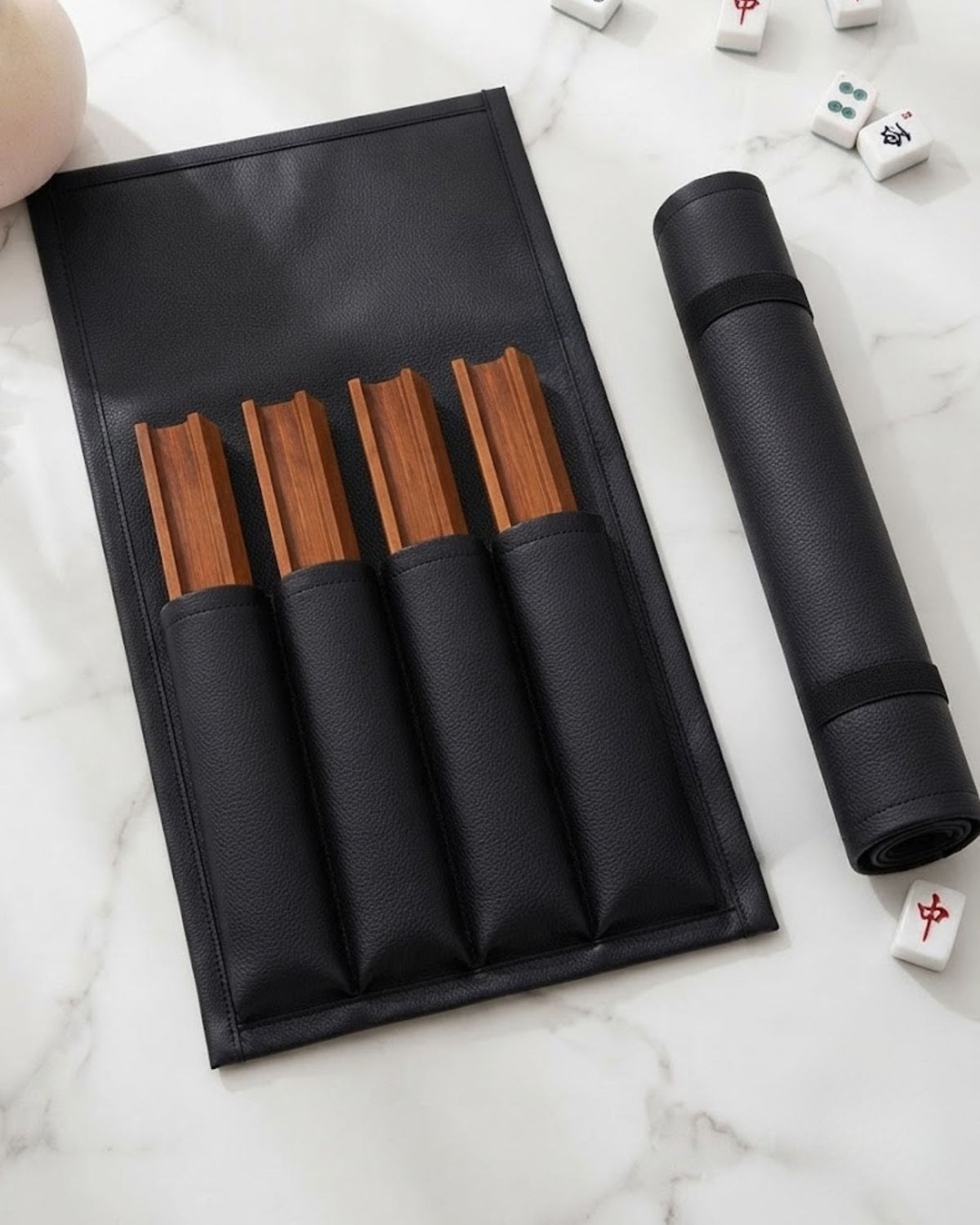 Black mahjong rack cover laid open, showing wooden divider slots and rolled tube.