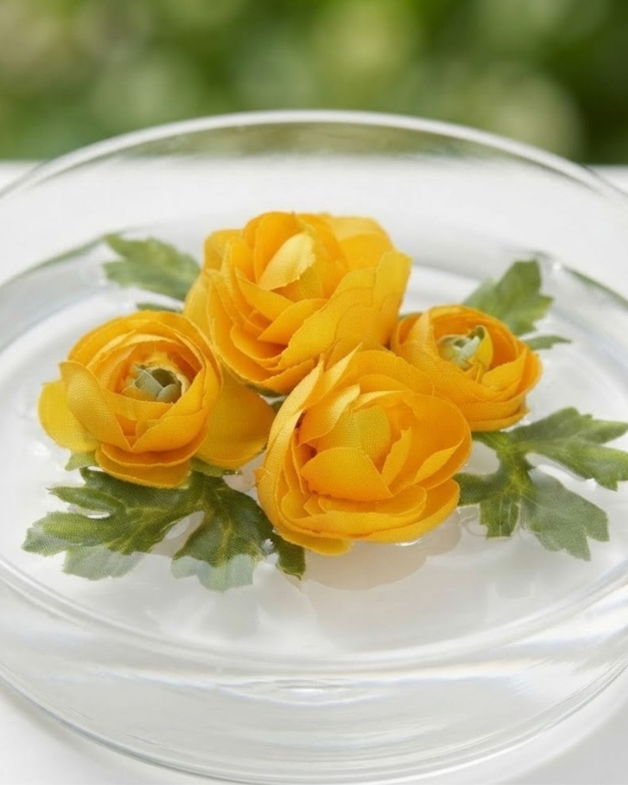 Close-up of artificial yellow rose-like floating flowers with green leaves in a lid