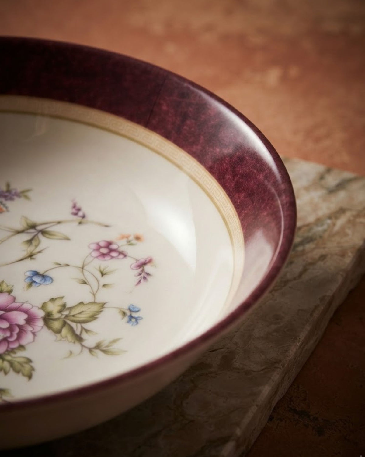 Close-up of maroon rim melamine serving bowl with floral bouquet border