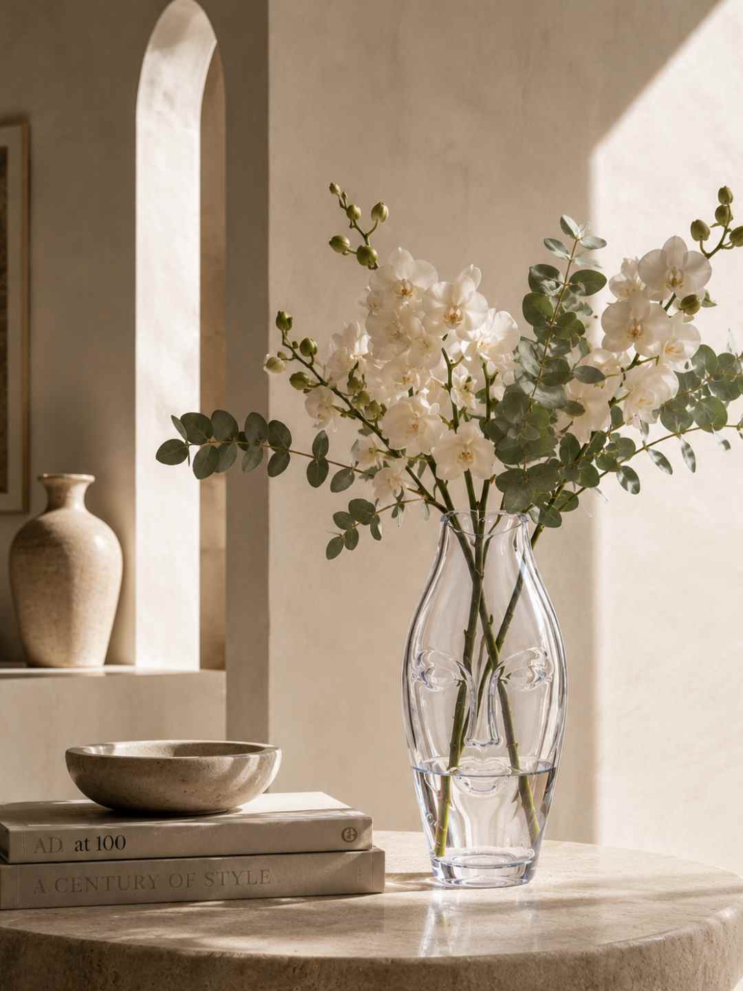 Clear glass face vase holding white flowers on a table display
