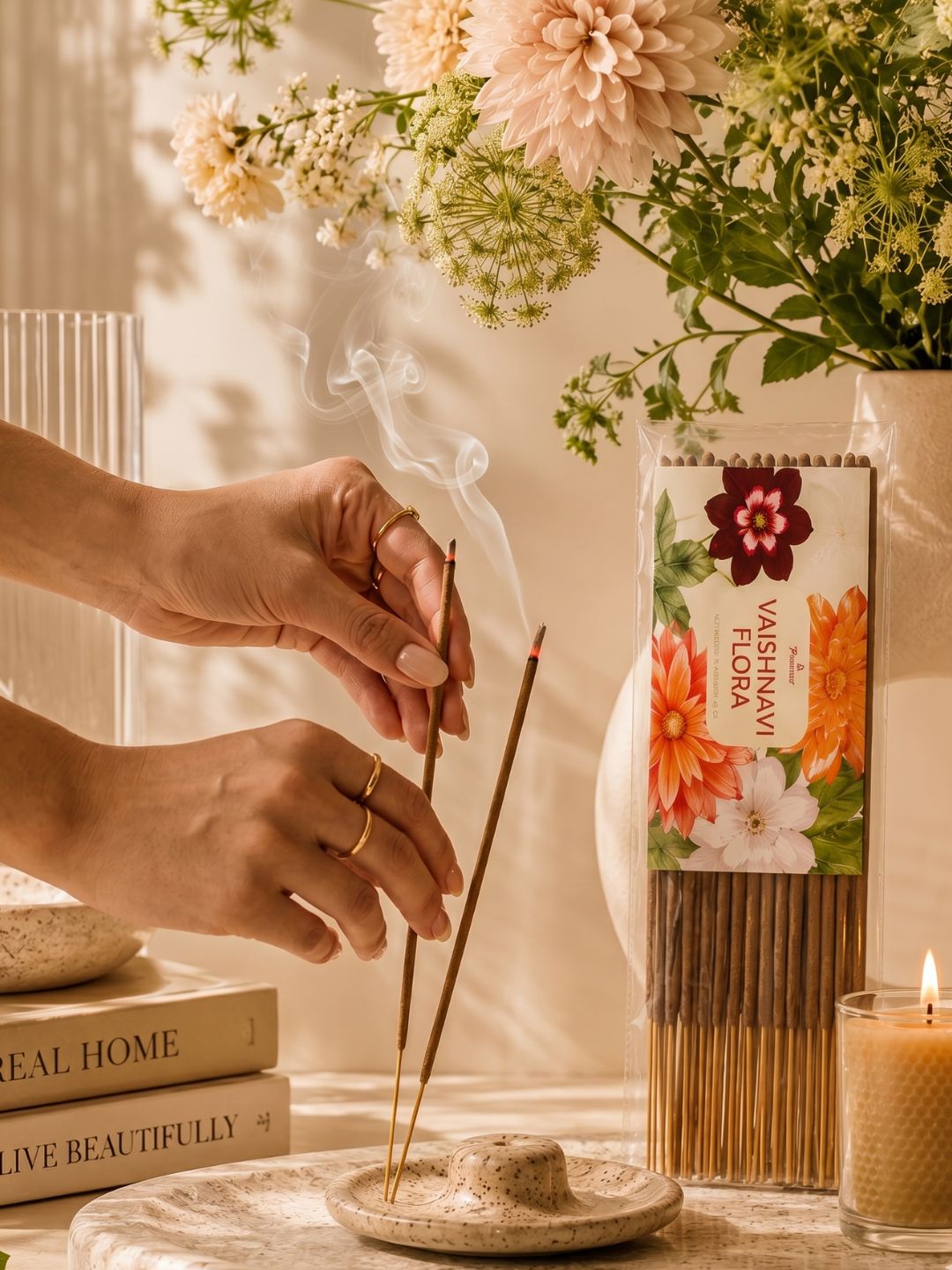 Person lighting an incense stick over a small wooden incense holder with smoke