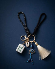 Evil eye mahjong keychain with blue beads, tassel charm, and white shell charm