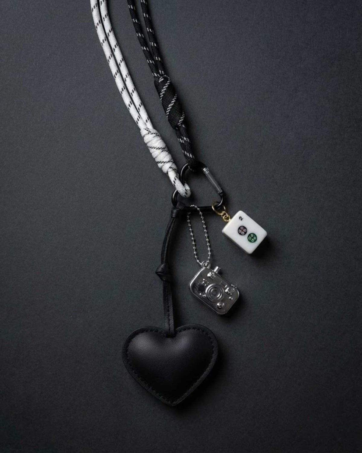 Black heart keychain charm with dangling metal piece and white mahjong tile