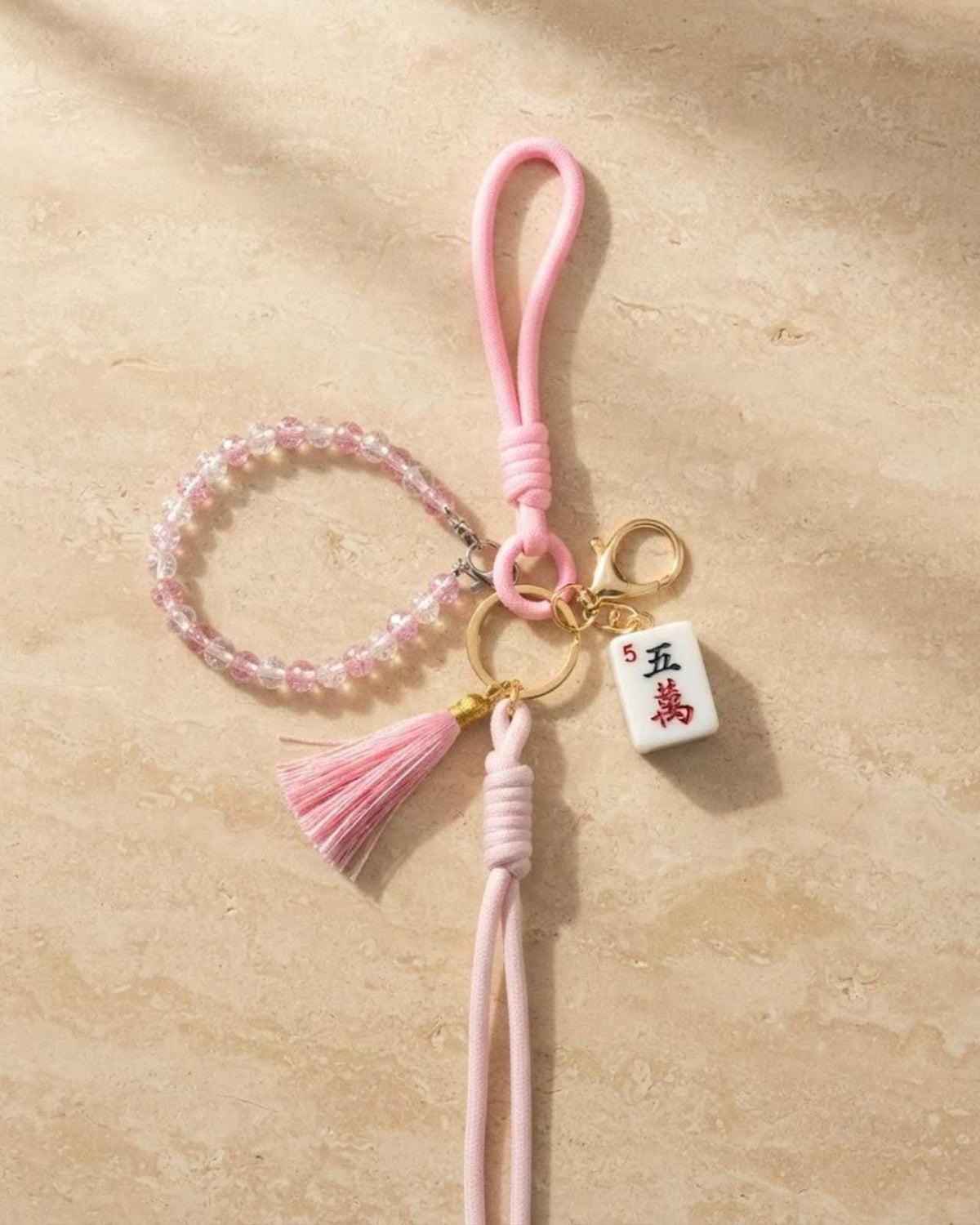 Pink pearl mahjong keychain with beaded ring, gold charm, tassel, and pink strap