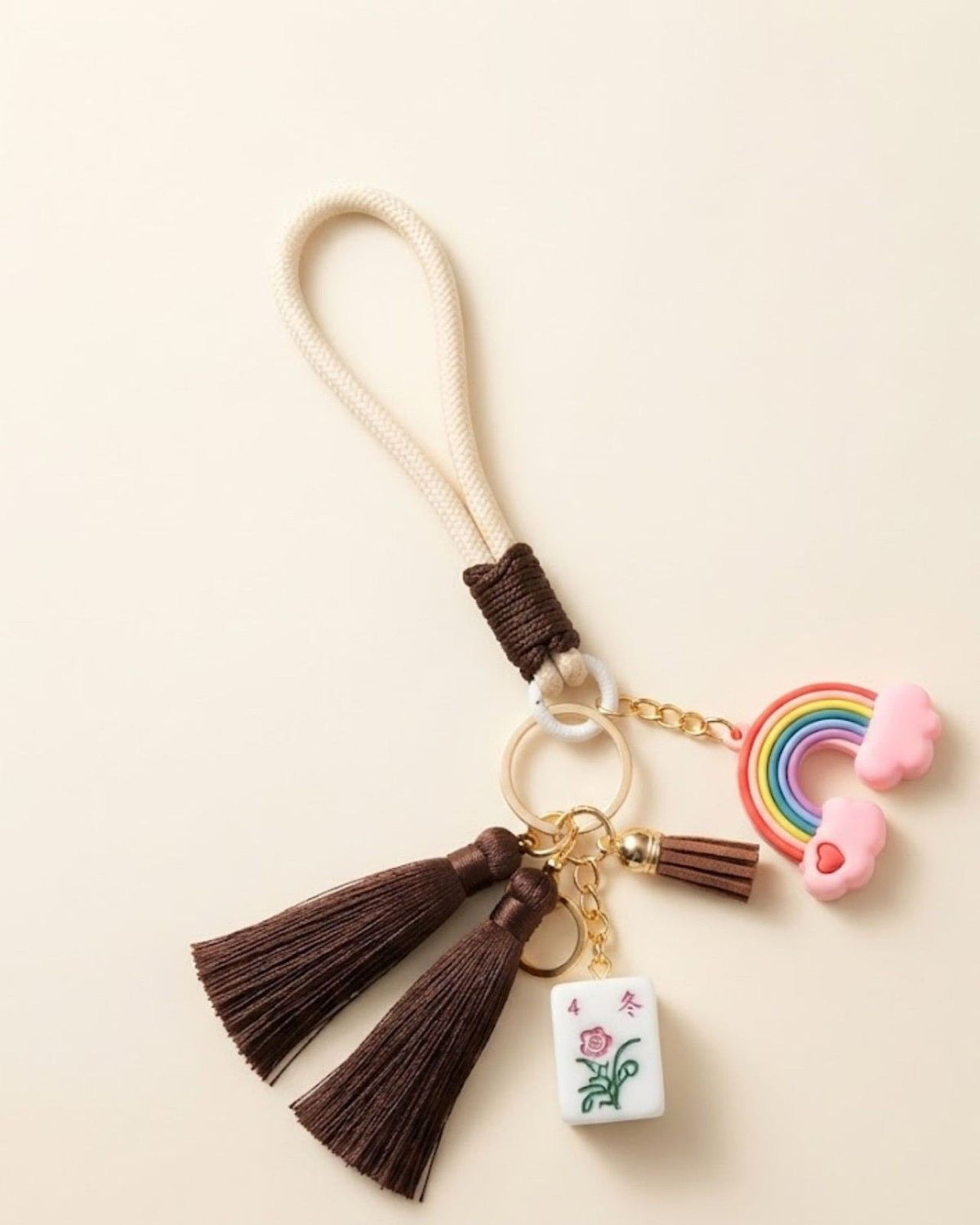Mahjong keychain with rainbow charm, brown tassels, and small tile pendant