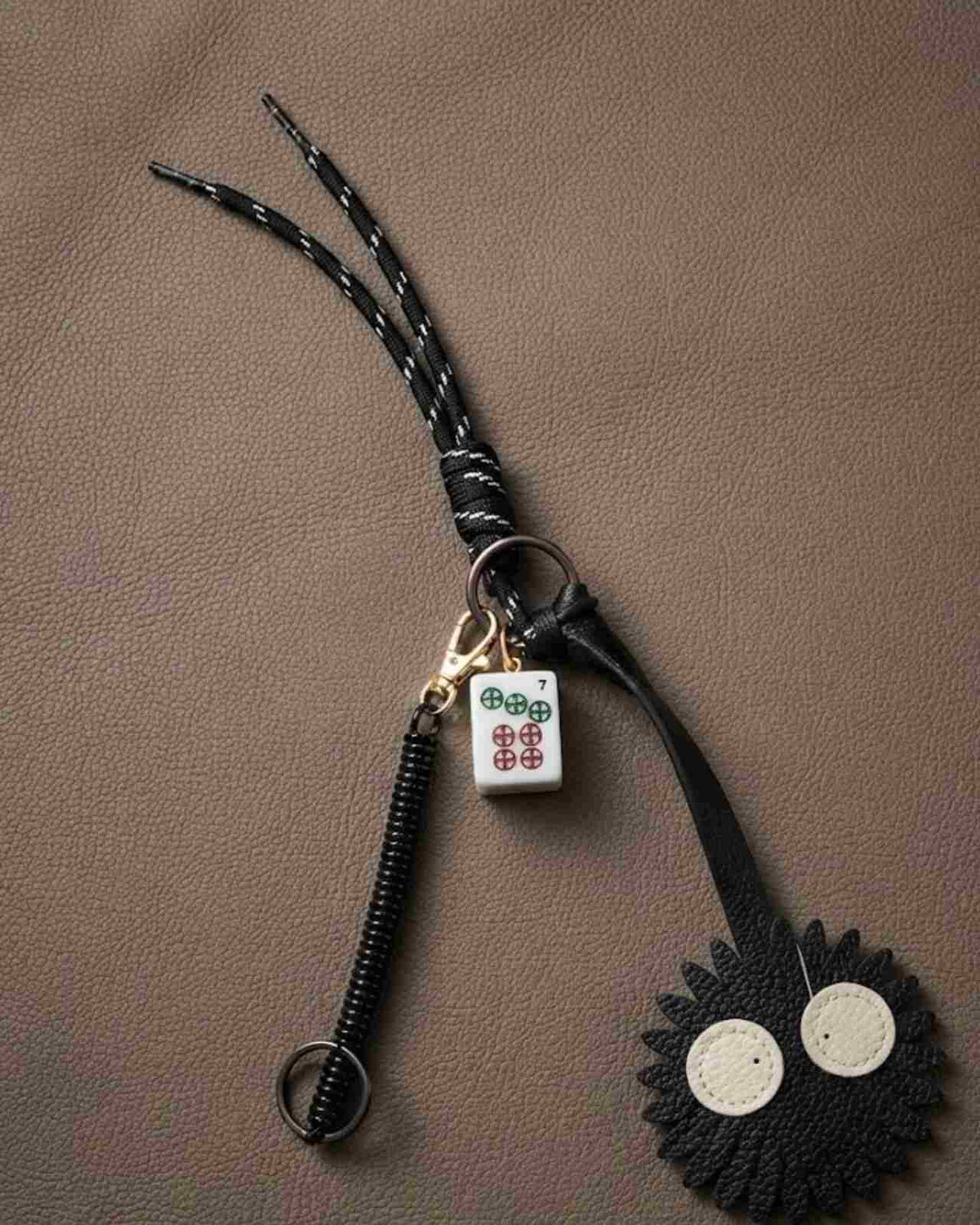 Black floral mahjong keychain with black loop and white tile charm with green symbols