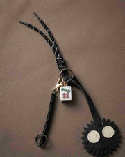 Black floral mahjong keychain with black loop and white tile charm with green symbols