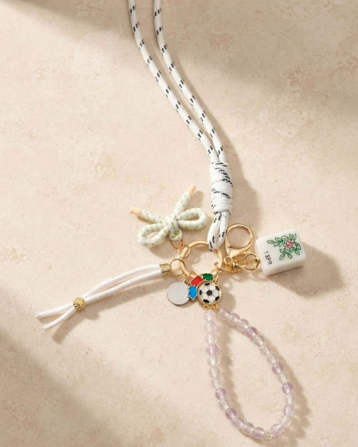 Multicolor tassel keychain with gold ring and small charm tile and soccer ball