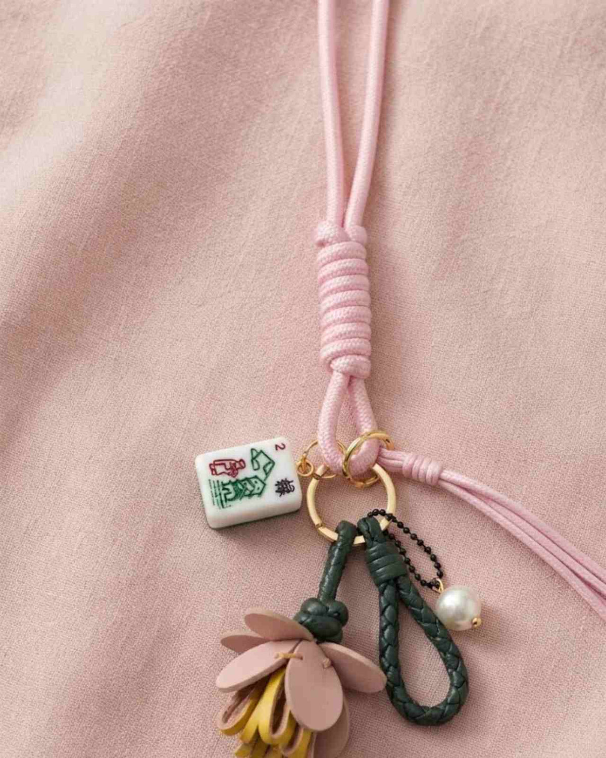 Leaf and flower keychain with small white mahjong tile charm on pink cord